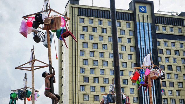 Seorang peserta panjat pinang yang tengah berusaha mengambil hadiah yang digantung di ujung pohon di halaman Hotel Wyndam Palembang, Sabtu (20/8) Foto: abp/Urban Id