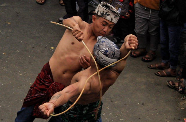 Pukulan rotan pemuda Tengger mendarat telak pada punggung lawannya dalam tradisi Ojung yang digelar dalam puncak Yadnya Karo ke-248 tahun 2022 di Desa Ngadas, Kecamatan Poncokusumo, Kabupaten Malang, Sabtu (20/8/2022). foto/Rubianto