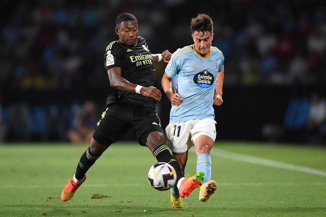 Bek Real Madrid David Alaba (kiri) bersaing dengan gelandang Celta Vigo, Franco Cervi dalam pertandingan sepak bola Liga Spanyol antara RC Celta de Vigo dan Real Madrid CF di stadion Balaidos di Vigo pada 20 Agustus 2022. Foto: Miguel Riopa/AFP
