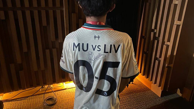 Fan memakai jersi Liverpool yang mengejek Manchester United (MU) saat menyambut Michael Owen di Jakarta pada Minggu, 21 Agustus 2022. Foto: Soni Insan Bagus/kumparan