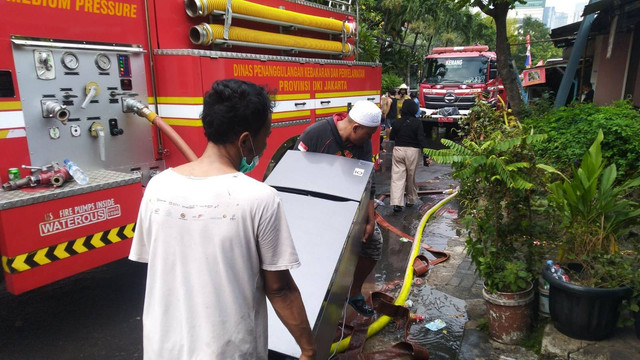 Warga sedang menyelamatkan barang-barang mereka saat terjadi kebakaran di Jalan Simprug Golf II, RT 08/08 Kelurahan Grogol Selatan, Kebayoran Lama, Minggu (21/8/2022). Foto: Ananta Erlangga/kumparan