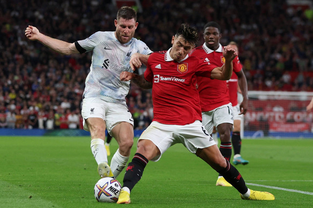 Pemain Manchester United Lisandro Martinez berebut bola dengan pemain Liverpool James Milner pada pertandingan lanjutan Liga Inggris di Old Trafford, Manchester, Inggris. Foto: Phil Noble/REUTERS