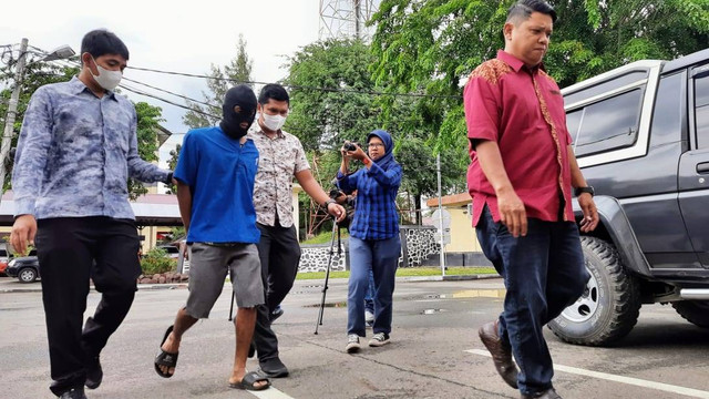 Pelaku RA dibawa polisi di Mapolda Aceh. Foto: Habil Razali/acehkini