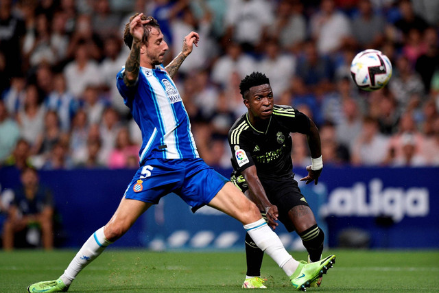 Pemain Real Madrid Vinicius Junior menembak ke gawang Espanyol di Stadion RCDE, Cornella de Llobregat, Spanyol, Minggu (28/8/2022). Foto: Pablo Morano/REUTERS