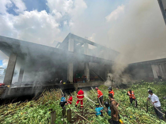 Petugas berusaha memadamkan api yang muncul di kolong gedung mangkrak di belakang RS Untan. Foto: Dok Hi!Pontianak