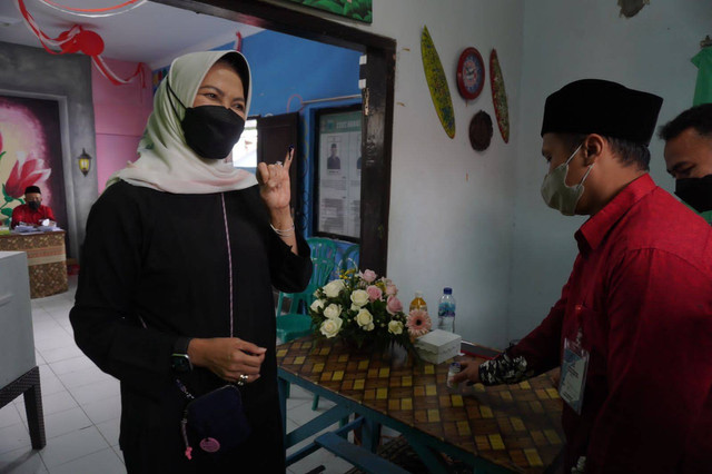 Wali Kota Batu, Dewanti Rumpoko saat ikut urun mencoblos suara dalam Pilkades serentak 2022, di TPS 23 Desa Pesanggrahan Kota Batu, pada Minggu (28/8/2022). Foto: Ulul Azmy