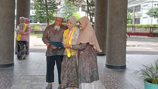Muryadi Ilyas (kiri) bersama anaknya, Indah Choirunisa berfoto bersama setelah perayaan wisuda UGM. Foto: dok. Pribadi
