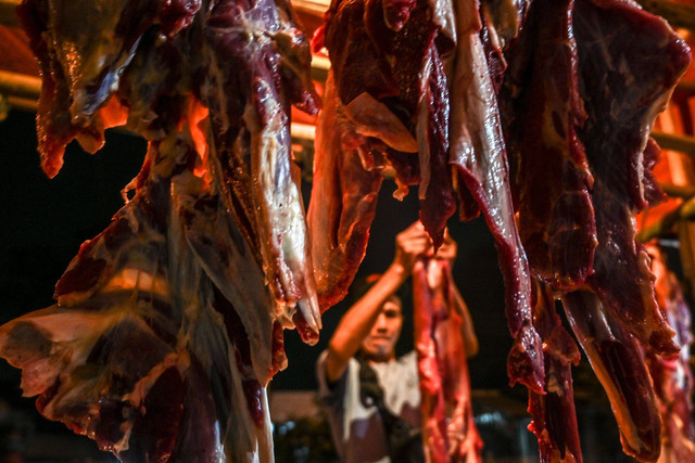 Pedagang memotong daging sapi untuk ditimbang di Pasar Cisalak, Depok, Jawa Barat, Sabtu (30/4/2022).  Foto: Muhammad Adimaja/ANTARA FOTO.