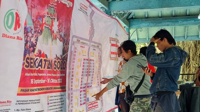 Pedagang mengamati denah stand Sekaten 2022 di Alun-alun Utara Keraton Solo, Selasa (30/08/2022). FOTO: Fernando Fitusia