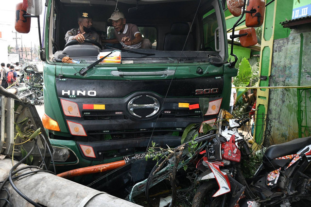 Petugas Kepolisian berusaha mengevakuasi sebuah truk kontainer yang menabrak halte bus di depan SDN Kota Baru II dan III di Jalan Sultan Agung, Bekasi, Jawa Barat, Rabu (31/8/2022). Foto: Fakhri Hermansyah/ANTARA FOTO