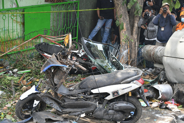 Dua jurnalis memotret sepeda motor yang rusak karena ditabrak truk kontainer di Jalan Sultan Agung, depan SDN Kota Baru 02 dan 03 Kranji, Bekasi, Jawa Barat, Rabu (31/8/2022).  Foto: Fakhri Hermansyah/ANTARA FOTO