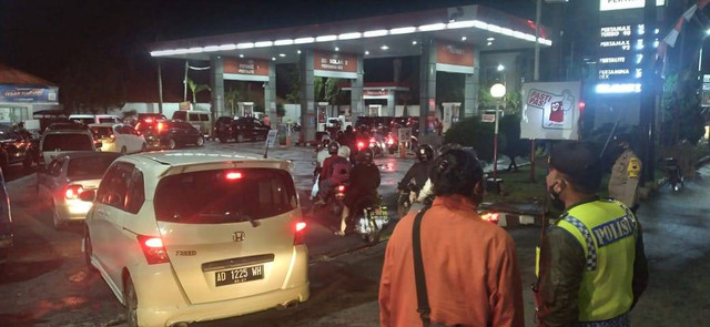 Polisi menjaga salah satu SPBU di Kota Temanggung yang terdapat antrean pembeliaan BBM, Rabu (31/8/2022) malam. Foto: ari/Tugu Jogja