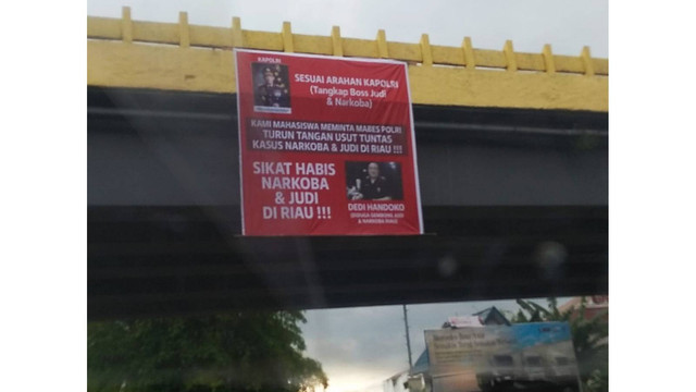 SPANDUK bertuliskan permintaan kepada Kapolri untuk turun tangan berantas judi dan narkoba di Riau terpasang di fly over Jalan Sudirman-Tuanku Tambusai, Kamis (1/9/2022). 