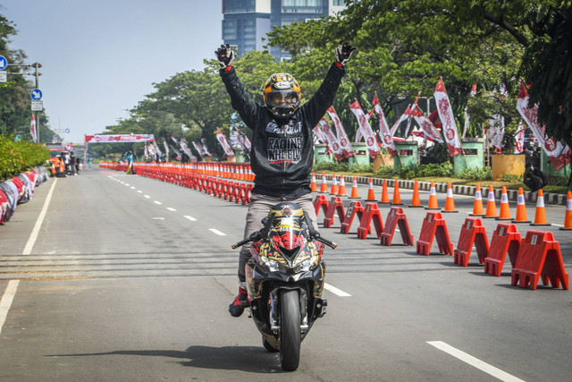 Peserta balap motor berselebrasi usai menang dalam kegiatan Street Race Polda Metro Jaya di Jalan Benyamin Sueb, Kemayoran, Jakarta Pusat, Sabtu (3/9/2022). Foto: Galih Pradipta/Antara Foto