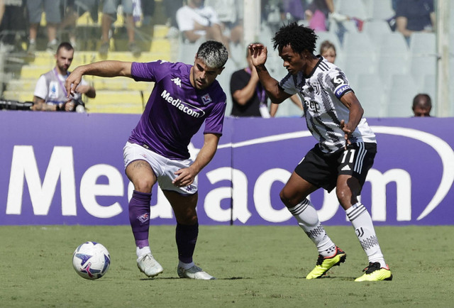 Pemain Juventus Juan Cuadrado beraksi dengan pemain Fiorentina Riccardo Sottil di Stadion Artemio Franchi, Florence, Italia, Sabtu (3/9/2022). Foto: Ciro De Luca/REUTERS