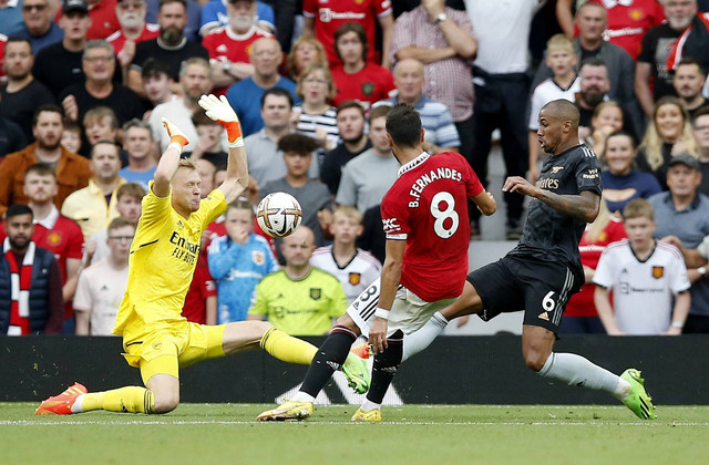 Pemain Arsenal Aaron Ramsdale melakukan penyelamatan dari pemain Manchester United Bruno Fernandes saat pertandingan di Old Trafford, Manchester, Inggris. Foto: Craig Brough/Reuters