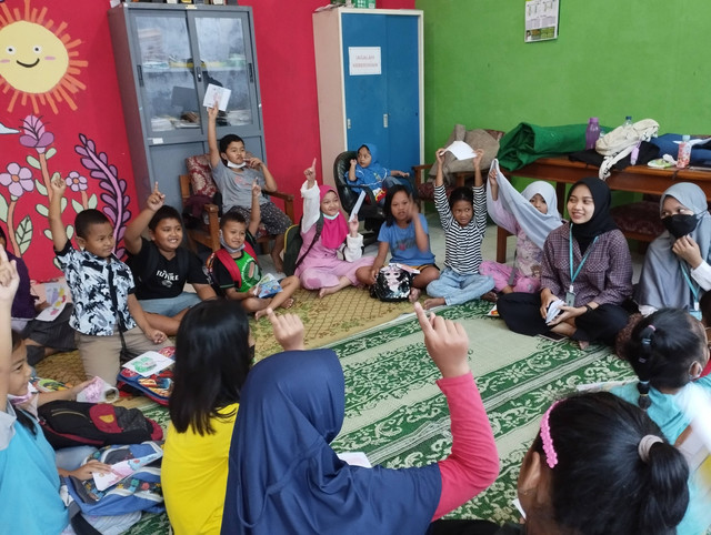 Gambar 1. Anak-anak mengacungkan tangan untuk menjawab pertanyaan                     Sumber: Dokumentasi Kegiatan, 2022