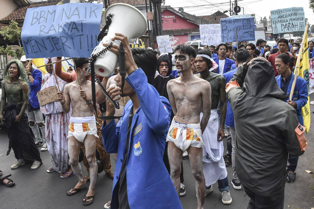 Mahasiswa yang tergabung dalam Pergerakan Mahasiswa Islam Indonesia (PMII) Kota Tasikmalaya menggelar aksi teatrikal tutup mulut di depan Depot terminal Pertamina Tasikmalaya, Kota Tasikmalaya, Jawa Barat, Senin (5/9/2022).  Foto: Adeng Bustomi/Antara Foto
