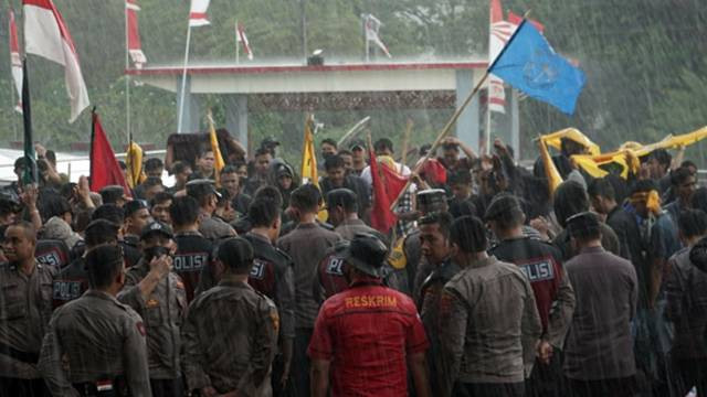 Ratusan mahasiswa di Manado dijaga kepolisian saat menggelar aksi penolakan kenaikan harga BBM di depan kantor DPRD Sulawesi Utara. Aksi mahasiswa kali ini dilakukan di bawah guyuran hujan lebat.