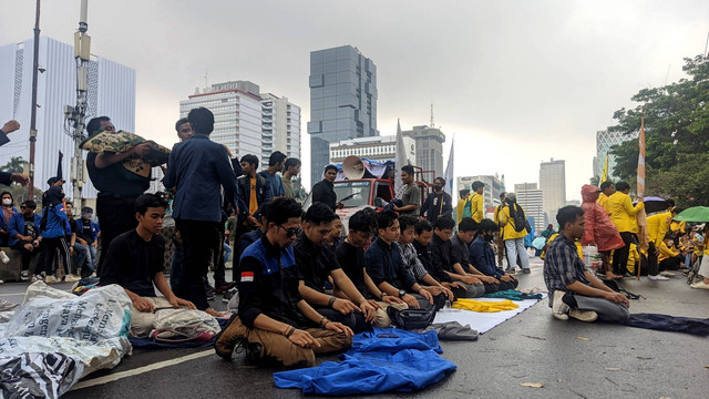 Massa aksi unjuk rasa tolak kenaikan harga BBM dari BEM SI melaksanakan ibadah salat di tengah guyuran hujan di kawasan Patung Kuda, Jakarta Pusat, Kamis (8/9/2022). Foto: Jonathan Devin/kumparan