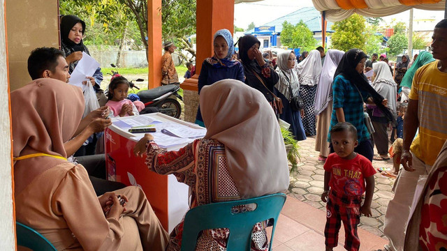 Keluarga penerima manfaat (KPM) di Kabupaten Aceh Barat antre menerima dana bantuan langsung tunai (BLT) BBM yang disalurkan melalui Kantor Pos Cabang Meulaboh, Kamis (8/9/2022). Foto: Siti Aisyah/acehkini