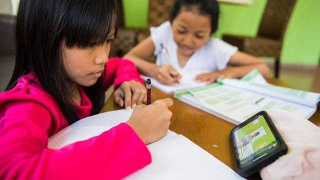 Dua anak menonton video belajar digital dari rumah di Bandung, Jawa Barat, Selasa (17/03/2020). Foto:  ANTARA/M Agung Rajasa