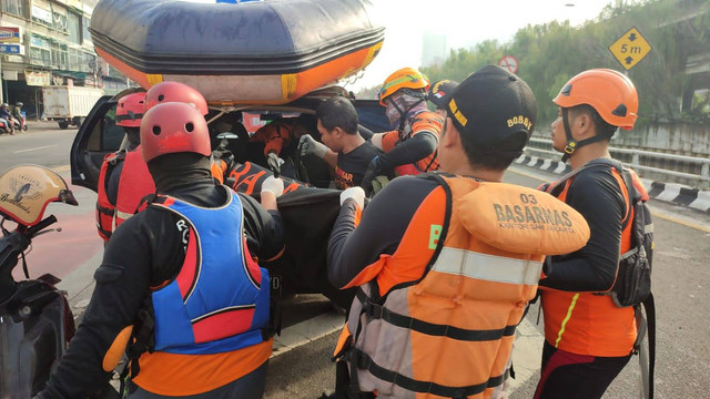 Tim SAR mengevakuasi satu korban kecelakaan di Tol Jelambar yang terpental ke Kali Grogol.  Foto: Dok. Istimewa