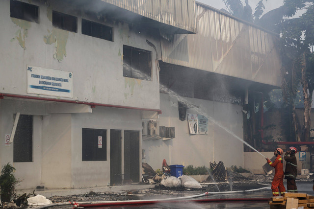 Petugas pemadam kebakaran menyemprotkan air guna memadamkan api di Gudang JNE, Pekapuran, Depok, Jawa Barat, Senin (12/9/2022). Foto: Asprilla Dwi Adha/Antara Foto