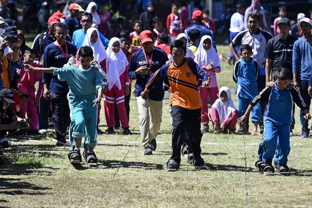 Siswa sekolah dasar mengikuti perlombaan dalam festival permainan anak tradisional di Banda Aceh, Sabtu (17/9/2022). Foto: Chaideer Mahyuddin/AFP