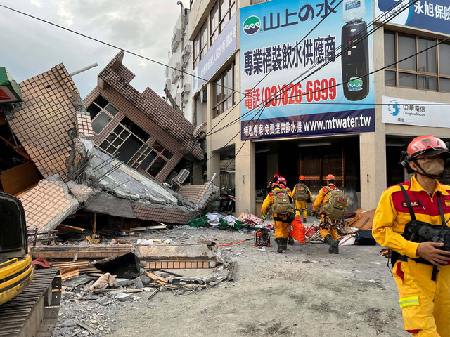 Petugas pemadam kebakaran bekerja di lokasi di mana sebuah bangunan runtuh setelah gempa berkekuatan 6,8, di Yuli, Hualien, Taiwan, Minggu (18/9/2022). Foto: Earthquake Central Emergency Operations Centre/Reuters