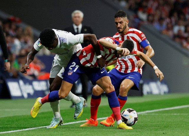 Pemain Real Madrid Eder Militao duel dengan Yannick Carrasco dari Atletico Madrid saat pertandingan di Metropolitano, Madrid, Spanyol. Foto: Susana Vera/Reuters