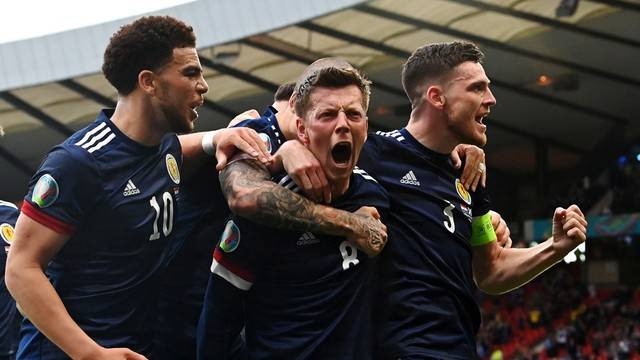 Pemain Skotlandia Callum McGregor berselebrasi dengan rekan setimnya, di Stadion Hampden Park, Glasgow, Skotlandia, Inggris, Selasa (22/6). Foto: Pool via REUTERS/Paul Ellis