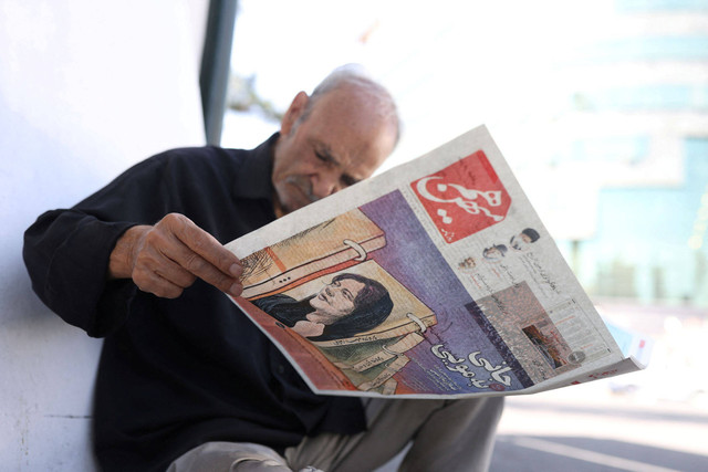 Koran dengan gambar sampul Mahsa Amini, seorang wanita yang meninggal setelah ditangkap oleh "polisi moral" republik Islam terlihat di Teheran, Iran.  Foto: Majid Asgaripour/WANA via Reuters