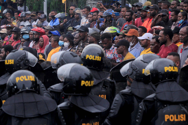 Massa pendukung Gubernur Papua Lukas Enembe berunjuk rasa menolak penetapan tersangka Gubernur Papua Lukas Enembe oleh Komisi Pemberantasan Korupsi (KPK) dengan pengamanan kepolisian di Titik Nol, Taman Imbi, Kota Jayapura, Papua, Selasa (20/9/2022). Foto: Gusti Tanati/Antara Foto