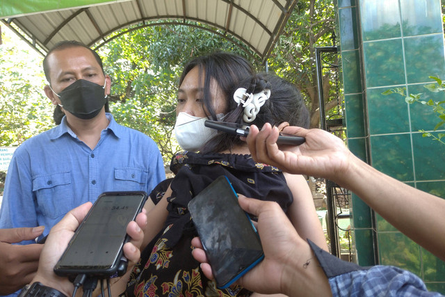 Theresia Alfita Saraswati anak sulung Iwan Boedi menggendong adik bungsunya usai pemakaman ayahnya. Foto: Intan Alliva/kumparan