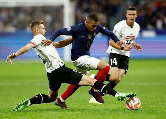 Pemain Prancis Kylian Mbappe duel dengan Stefan Posch dan Dejan Ljubicic dari Austria saat pertandingan UEFA Nations League Grup A di Stade de France, Saint-Denis, Prancis, Kamis (22/9/2022). Foto: Christian Hartmann/Reuters