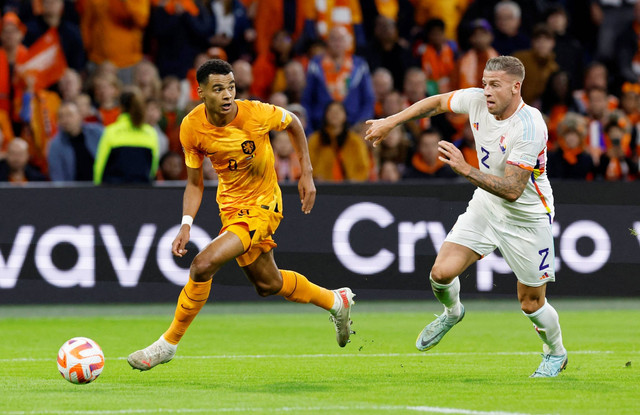 Pemain Belanda Cody Gakpo beraksi bersama pemain Belgia Toby Alderweireld di Johan Cruijff Arena, Amsterdam, Belanda, Minggu (25/9/2022). Foto: Piroschka Van De Wouw/REUTERS