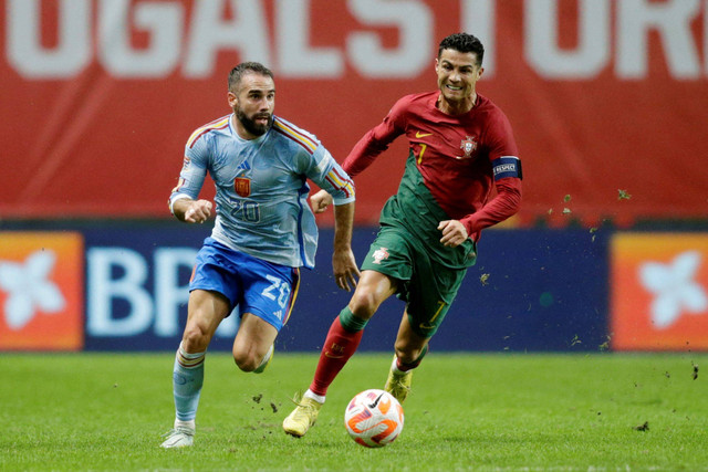 Pemain Timnas Portugal Cristiano Ronaldo berusaha berebut bola dengan pemain Timnas Spanyol Dani Carvajal pada pertandingan Grup B UEFA Nations League di Estadio Municipal de Braga, Braga, Portugal. Foto: Miguel Vidal/REUTERS