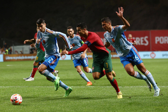 Pemain Timnas Portugal Cristiano Ronaldo berusaha melewati pemain Timnas Spanyol Rodri dan Alvaro Morata pada pertandingan Grup B UEFA Nations League di Estadio Municipal de Braga, Braga, Portugal. Foto: Pedro Nunes/REUTERS