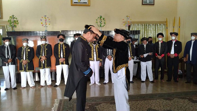 Sultan Ternate, Hidayatullah Sjah, menyematkan lastar ngare sekaligus  menganugerahkan gelar ke Presiden Joko Widodo di Kedaton Kesultanan Ternate. Dok: Kesultanan Ternate