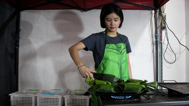 Melati eks JKT48 tengah membakar nasi bakar. Foto: Riad Nur Hikmah/kumparan