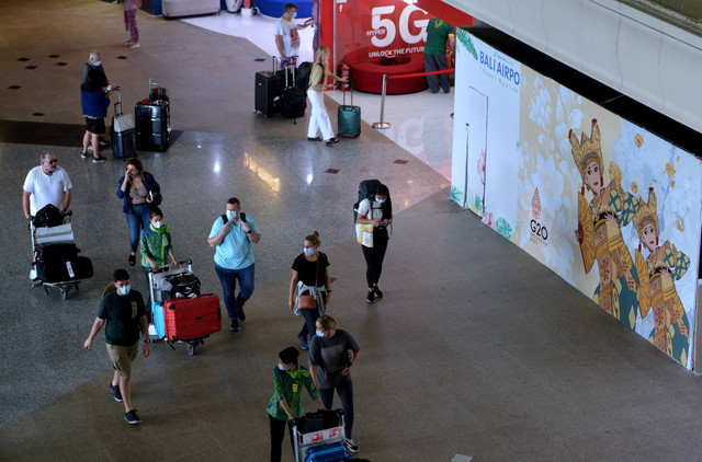 Sejumlah penumpang pesawat membawa barang bawaannya di area Terminal Internasional Bandara I Gusti Ngurah Rai, Badung, Bali, Kamis (29/9/2022). Foto: Fikri Yusuf/ANTARA FOTO
