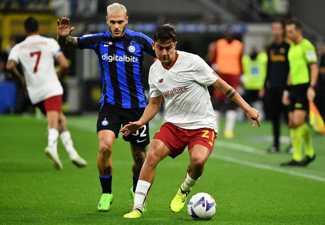 Pemain depan AS Roma asal Argentina Paulo Dybala bekerja di sekitar bek Inter Milan Federico Dimarco (kiri) selama pertandingan sepak bola Serie A Italia antara Inter dan AS Roma pada 1 Oktober 2022 di stadion Giuseppe-Meazza (San Siro) di Milan. Foto: Isabella BONOTTO / AFP