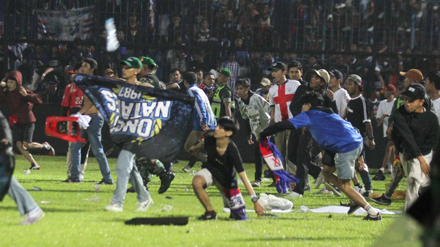 Suporter Arema FC memasuki lapangan setelah tim yang didukungnya kalah dari Persebaya dalam pertandingan sepak bola BRI Liga 1 di Stadion Kanjuruhan, Malang, Sabtu (1/10/2022).  Foto: Ari Bowo Sucipto/ANTARA FOTO