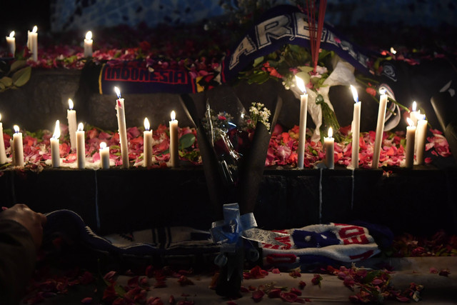 Sejumlah lilin dinyalakan di depan Patung Singa Stadion Kanjuruhan, Malang, jawa Timur, Minggu (2/10/2022). Foto: Zabur Karuru/Antara Foto
