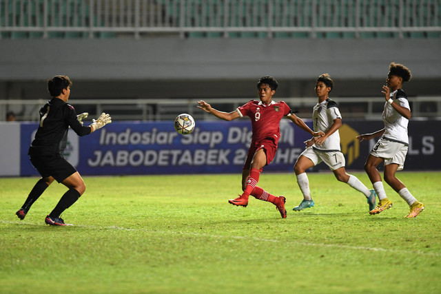 Pesepak bola Tim Nasional U-17 Indonesia Muhammad Rizky (kedua kiri) berusaha mengecoh kiper Tim Nasional U-17 Guam Jacob Toves (kiri) dalam laga Grup B Kualifikasi Piala Asia U-17 2023 di Stadion Pakansari, Cibinong. Foto: Aditya Pradana Putra/ANTARA FOTO