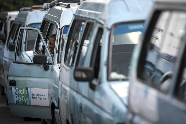Seorang sopir angkutan kota Mikrotrans berada di dalam armadanya di Terminal Pulo Gadung, Jakarta, Selasa (4/10/2022). Foto: M Risyal Hidayat/ANTARA FOTO
