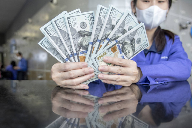 Petugas menunjukan uang pecahan Rupiah dan dolar AS di gerai penukaran mata uang asing VIP (Valuta Inti Prima) Money Changer, Jakarta, Selasa (4/10/2022). Foto: Muhammad Adimaja/Antara Foto