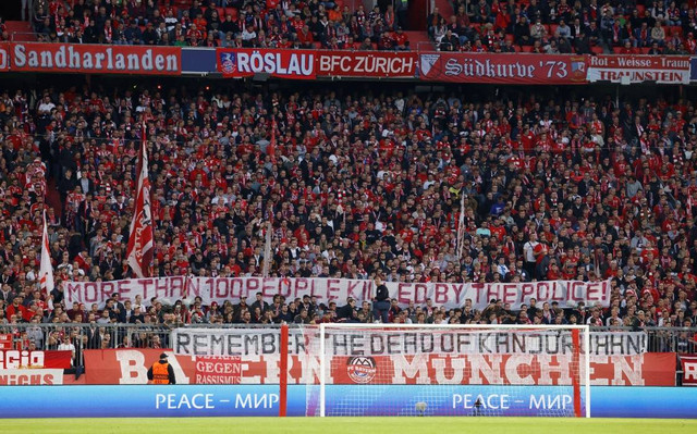 Penggemar Bayern Muenchen memasang spanduk di tribun sebelum pertandingan di Allianz Arena, Munich, Jerman. Foto: Michaela Rehle/Reuters