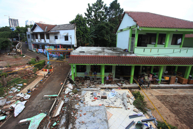 Sejumlah petugas mengamati tembok roboh akibat banjir di MTSN 19 Pondok Labu, Jakarta,  Jumat (7/10/2022).  Foto: Reno Esnir/ANTARA FOTO